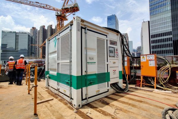 Containerized battery energy storage unit powering a tower crane on a high-rise construction site