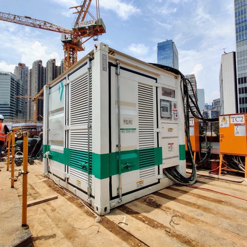 Containerized battery energy storage unit powering a tower crane on a high-rise construction site